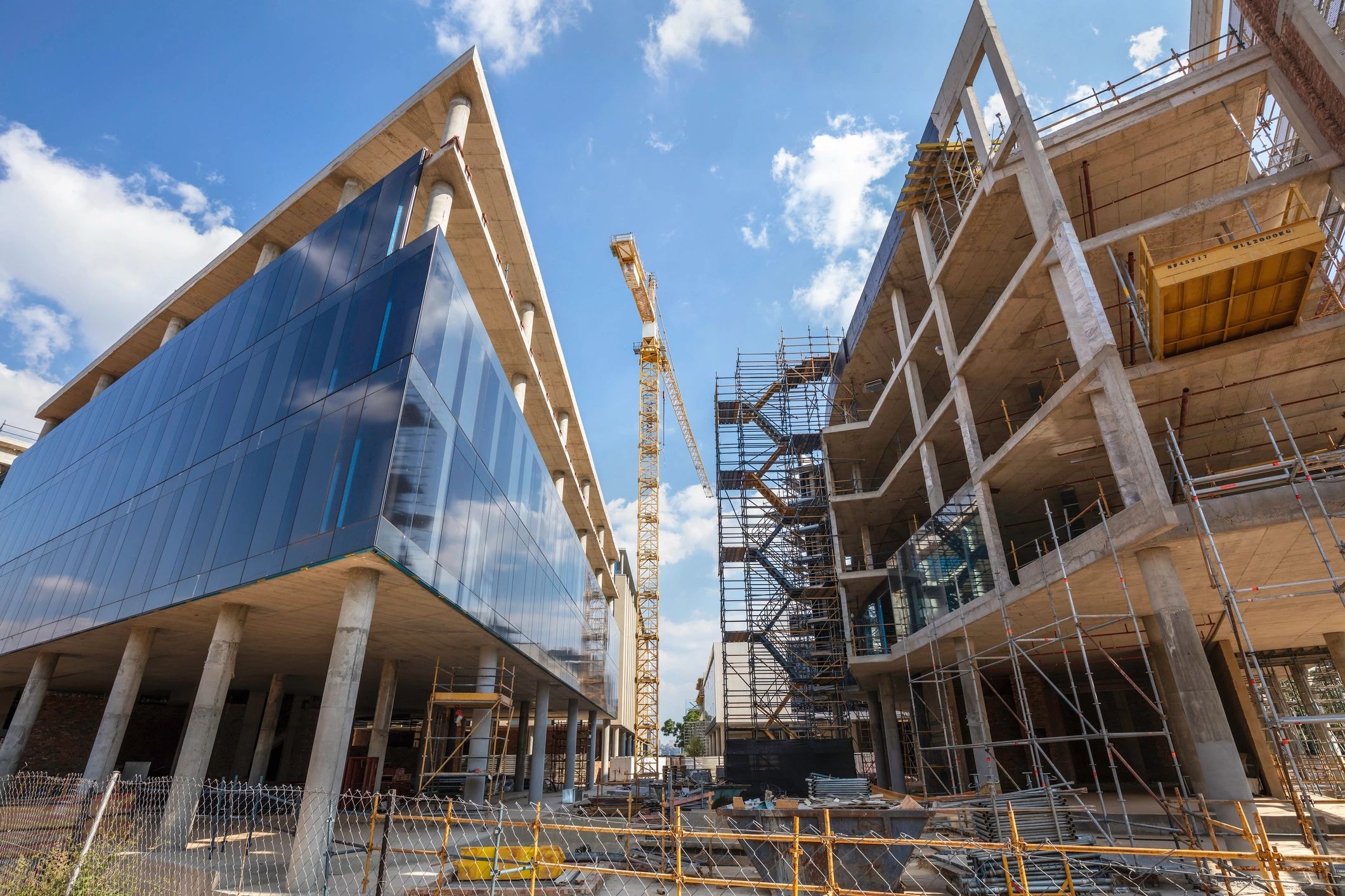 Modern buildings under construction with cranes